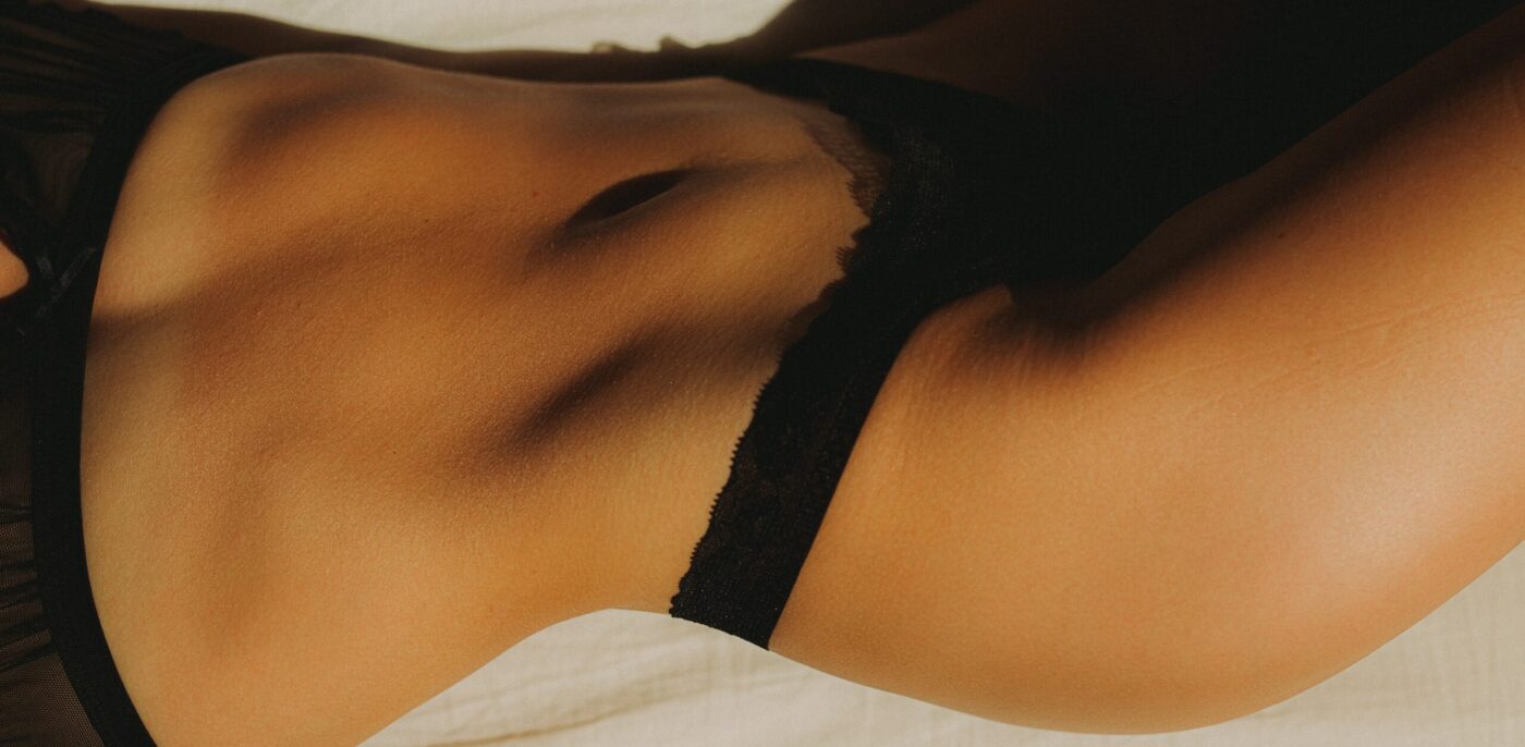 woman in black panty lying on bed